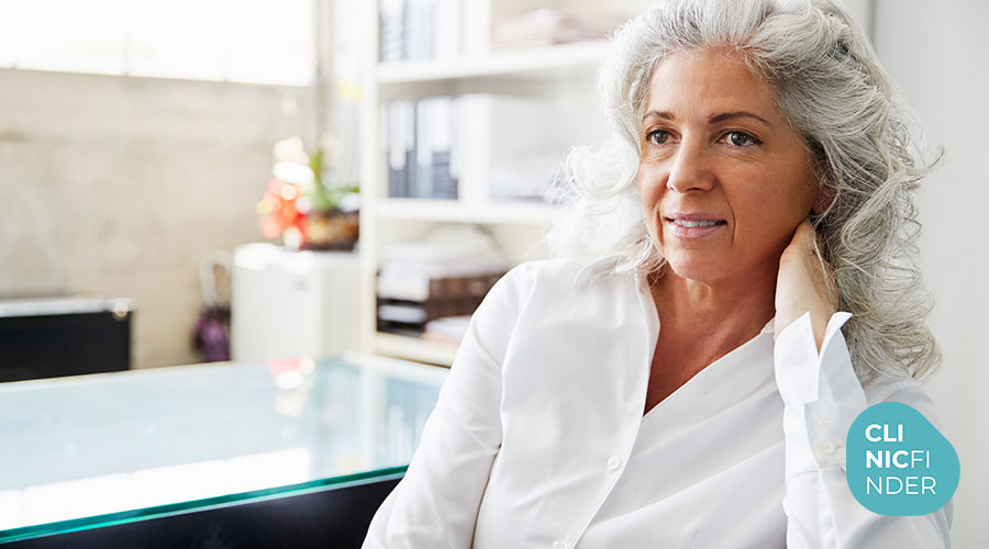 Older woman standing in a bright clinic