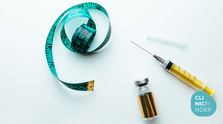 Syringe, vial and measuring tape arranged on a clinical surface